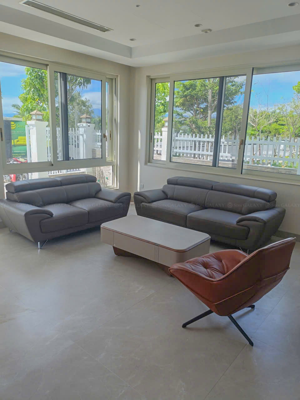 Sofa Vichy da bò thật màu xám cùng ghế xoay Bolo tại nhà khách Cam Ranh góc nghiêng